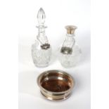 A SILVER MOUNTED BOTTLE COASTER AND TWO DECANTERS (5)