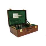 A GEORGE VI SILVER MOUNTED GLASS DRESSING SET IN A FITTED CROCODILE LEATHER SUITCASE