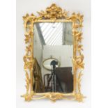 A GEORGE III GILT FRAMED MIRROR WITH PIERCED AND CARVED FLORAL CHASED FRAMED