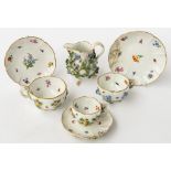 A MEISSEN FLOWER ENCRUSTED MILK JUG, THREE CUPS AND SAUCERS (7)
