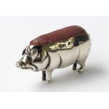 A SILVER PIN CUSHION MODELLED AS A STANDING PIG