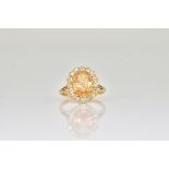 A GOLD, TOPAZ AND DIAMOND OVAL CLUSTER RING