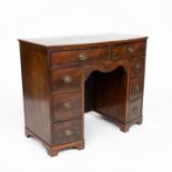 AN EARLY 19TH CENTURY MAHOGANY BOW FRONT KNEEHOLE WRITING DESK