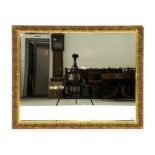 A MODERN GILT FRAMED MIRROR WITH FLORAL CHASED FRAME