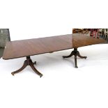 A REGENCY STYLE MAHOGANY TWIN PEDESTAL EXTENDING DINING TABLE