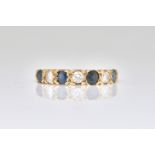 A 9CT GOLD SAPPHIRE AND DIAMOND SET SEVEN STONE HALF HOOP RING