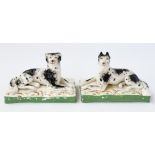 AN UNUSUAL PAIR OF STAFFORDSHIRE PORCELAIN WORKING DOGS (2)