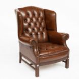 A GEORGE II STYLE STUDDED TAN LEATHER UPHOLSTERED WING BACK ARMCHAIR