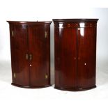 A GEORGE III MAHOGANY BOWFRONT HANGING CORNER CUPBOARD (2)