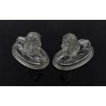 JOHN DERBYSHIRE: A PAIR OF VICTORIAN PRESSED GLASS RECUMBENT LIONS (2)