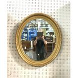 A GILT PAINTED OVAL MIRROR