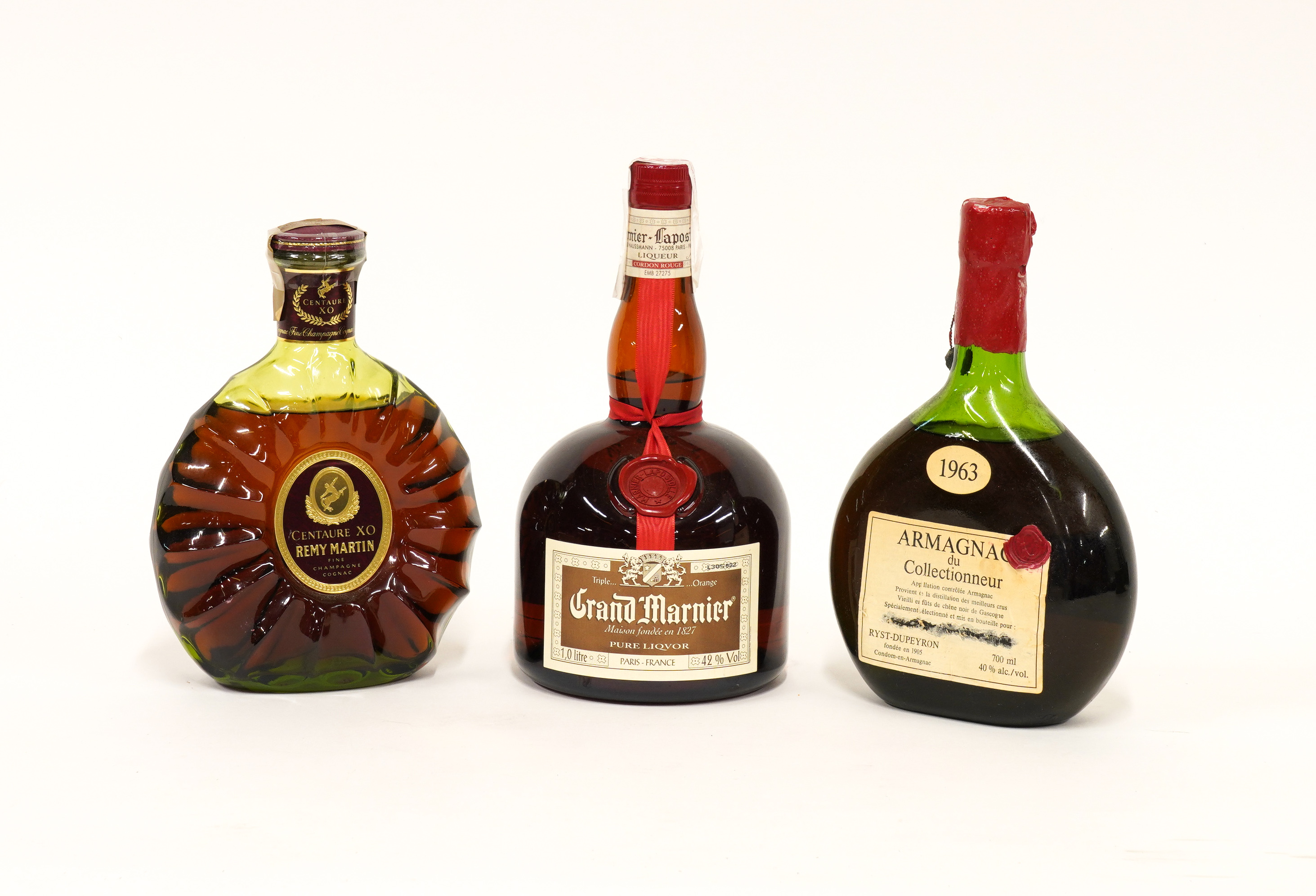 THREE BOTTLES INCLUDING REMY MARTIN CENTAURE XO FINE COGNAC, GRAND MARNIER AND BREVET ARMAGNAC...