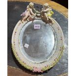 AN OVAL MEISSEN-STYLE MIRROR DECORATED WITH TWO CHERUBS