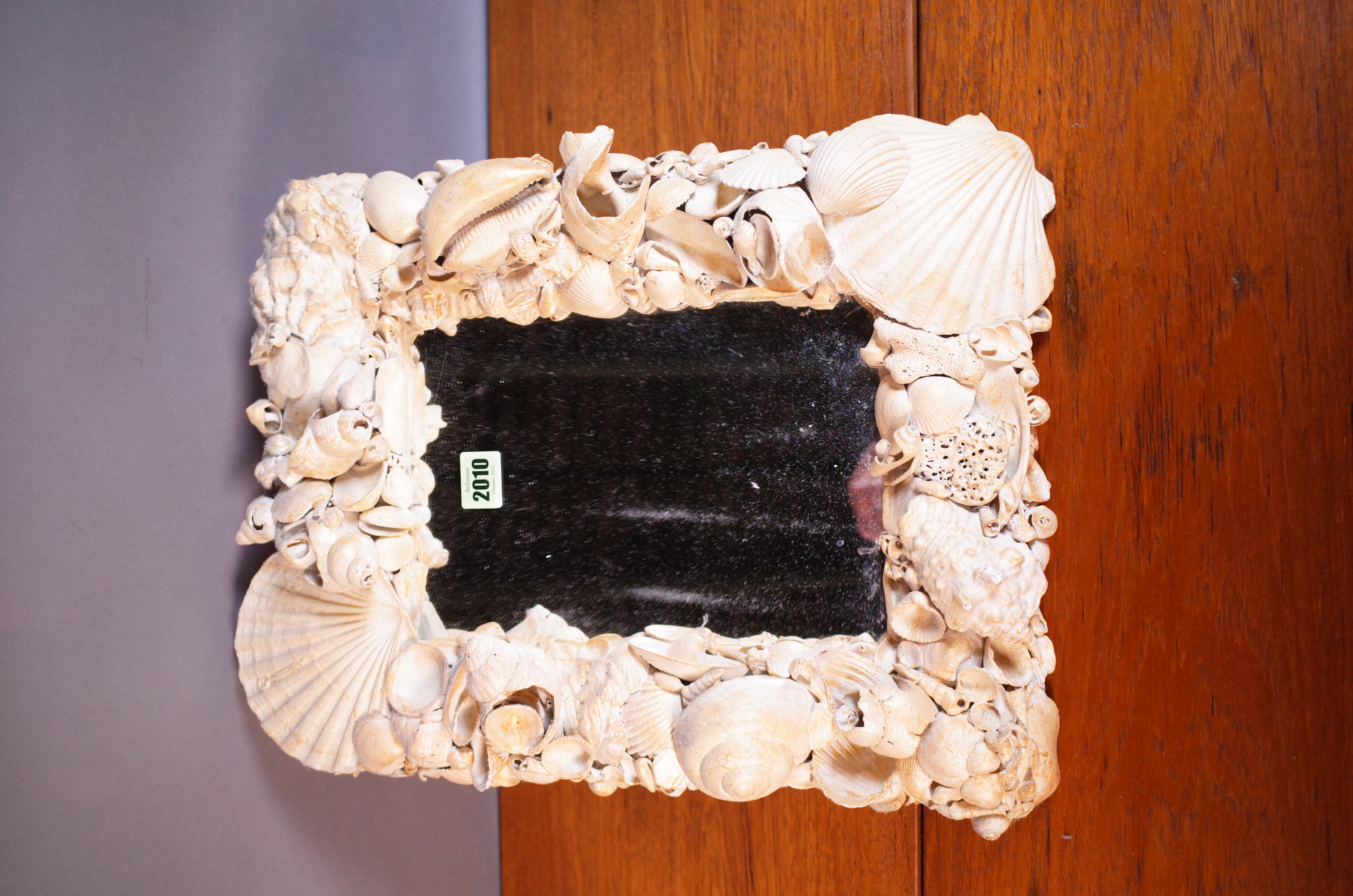 A MODERN WALL MIRROR APPLIED WITH SHELLS.