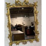 A MODERN GILT FRAMED MIRROR WITH FOLIATE CARVED FRAME