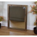 A GOLD PAINTED METAL WALL MIRROR WITH HANGING SUPPORTS