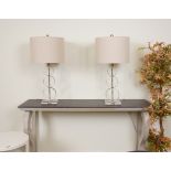 LIGHTING, A PAIR OF CHROME AND GLASS TABLE LAMPS WITH GREY COTTON SHADES