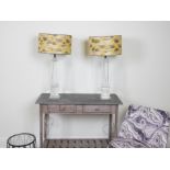 LIGHTING, A PAIR OF HEAVY CUT GLASS TABLE LAMPS OF COLUMN FORM, WITH GOLD AND SILVER SILK SHADES