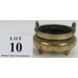 An antique Chinese bronze censer raised on trilobed three feet and with rope twist handles. Six