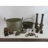 A collection of old ironwork and weights including two gate finials, gin trap and two cauldrons. (