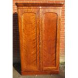 A Victorian mahogany double wardrobe with removeable cornice over twin doors opening onto an array