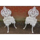 A pair of antique cast iron garden chairs with ornately cast & pierced backrests and radial seats,