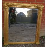A large bevelled rectangular giltwood overmantle mirror, flanked by Corinthian columns with