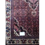 A smart Bijar Persian rug. with central motif on a claret field and cream border in very good condi