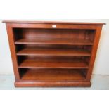 A bespoke low cherrywood open bookcase with three height adjustable loose shelves, raised on a