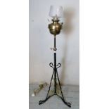 A Victorian wrought iron and brass height adjustable standard lamp, converted from oil to