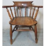 A turn of the century elm & beech smokers bow chair, with baluster turned spindles, raised on turned