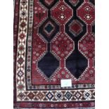 A fine quality Lori rug. A central repeat pattern on a deep burgundy ground. 2.20 x 1.47. Good colo