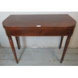 A George III mahogany turnover tea table, crossbanded and strung with satinwood & ebony, raised on