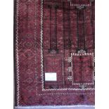 A Turkoman rug on deep burgundy ground with highlights of cream. 2.30m x 1.30m. Condition is good.
