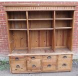 A large vintage pitch pine dresser/bookcase with carved cornice over an array of shelving and