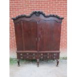 An 18th century Spanish oak linen press with ornately carved pierced shaped cornice over twin