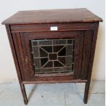 An Edwardian mahogany side cabinet, featuring an inset stained glass panel, raised on square