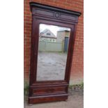 A turn of the century figured mahogany armoire featuring moulded cornice and bevelled mirror door.