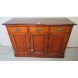 A late Victorian mahogany sideboard with three short drawers fitted with fancy pressed brass