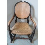 A turn of the century elm & beech rocking chair with a bergère backrest & braided rope seat,