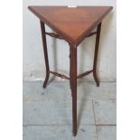 A diminutive Edwardian mahogany triangular side table in the Arts & Crafts taste, raised on outswept