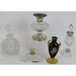 Four antique cut glass perfume bottles, three with silver mounts, one enamelled, plus a small French