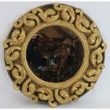 A circular gilt plaster mirror with deep relief Rococo border by Alan Wallis Designs. Condition