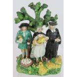 An early Staffordshire pottery group figure depicting a couple with baby and parson. Height 17.