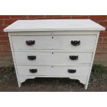 An Edwardian oak chest of drawers of small proportions, with three long drawers fitted with