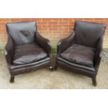 A pair of 19th century club armchairs, upholstered in chocolate brown leather with brass studs,