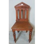 A 19th century oak hall chair, with architectural carved backrest in the form of a Corinthian