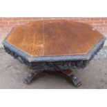 A 19th century oak octagonal tilt-top pedestal table, with foliate carved and pierced frieze