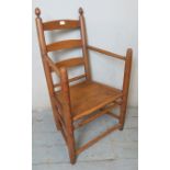 A 19th Century elm & beech ladderback open sided armchair with turned finials, on round