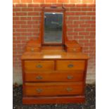 An Edwardian yew wood dressing chest with bevelled mirror flanked by two small drawers, over two
